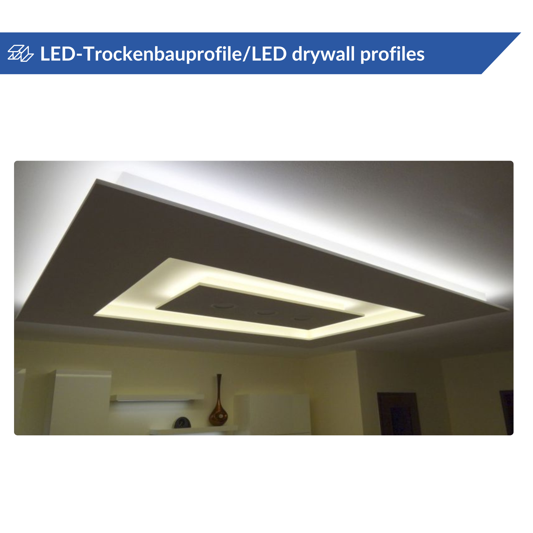 Lichtdecke mit eingebautem LED-Trockenbauprofil, das ein rechteckiges Design aufweist und weiches, weißes Licht abgibt. Darunter ist teilweise ein Regal mit Dekorationsgegenständen sichtbar.